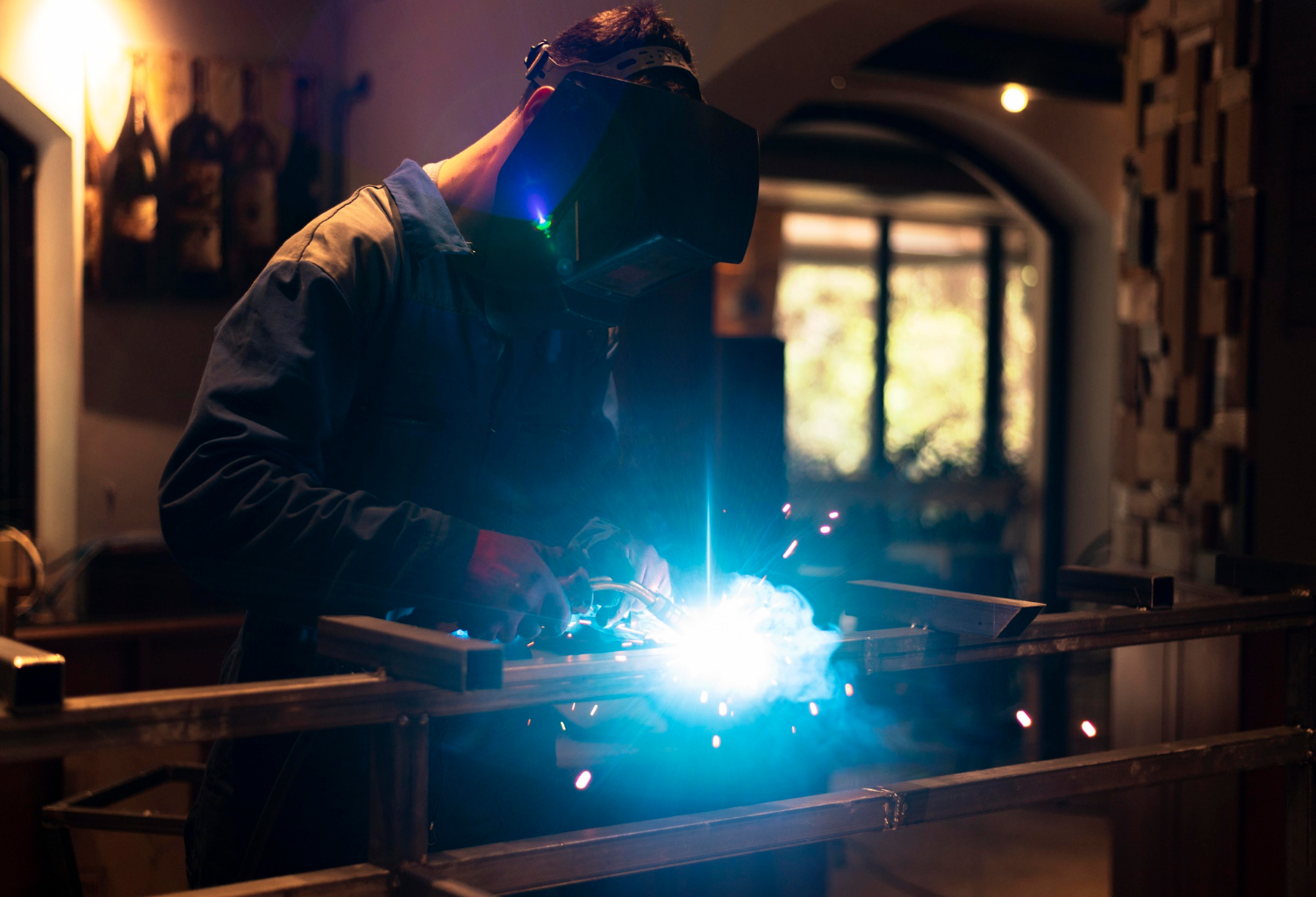 man-with-mask-welding-metal-atelier